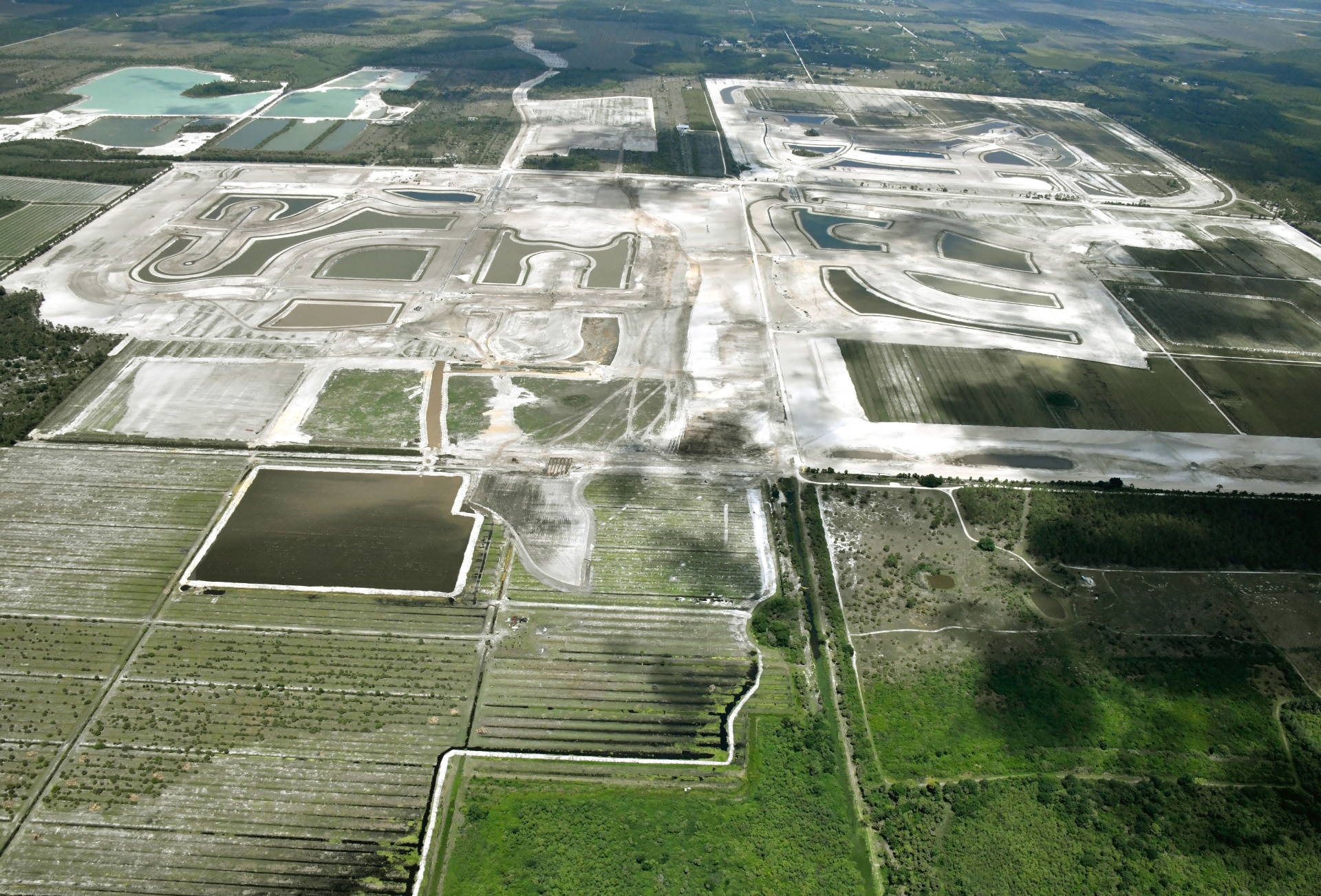 Aerial photo of Kingston in Estero, Florida showing curved lakes, road networks and cleared parcels bordering preserve and farmland